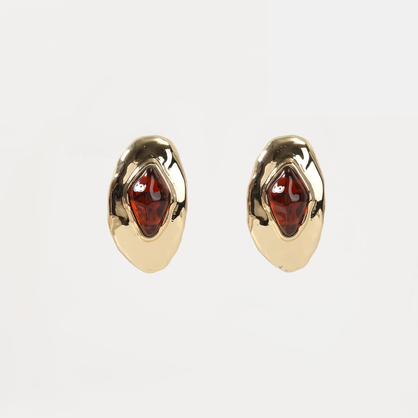 Gold organic-shaped stud earring with amber-colored stone